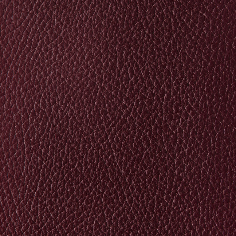 Nahaufnahme von burgunderfarbenem Leder mit strukturierter Oberfläche, ideal für Möbel, Taschen und Accessoires.